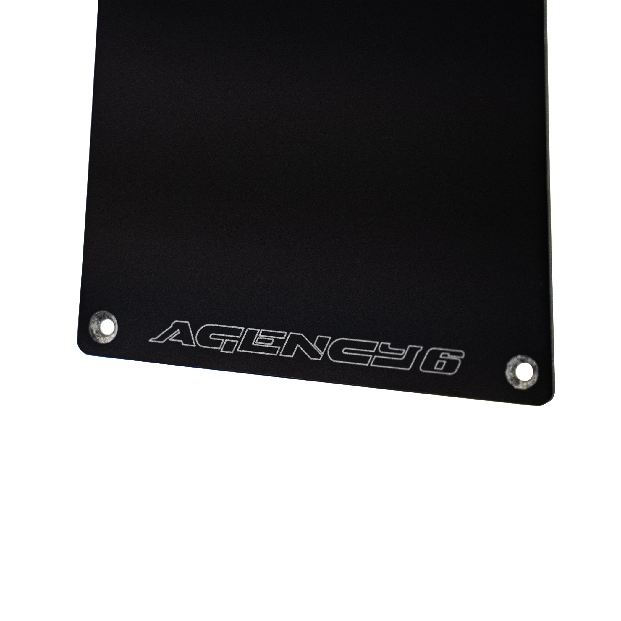 Black metal plate with 'Agency 6' engraving on a white background