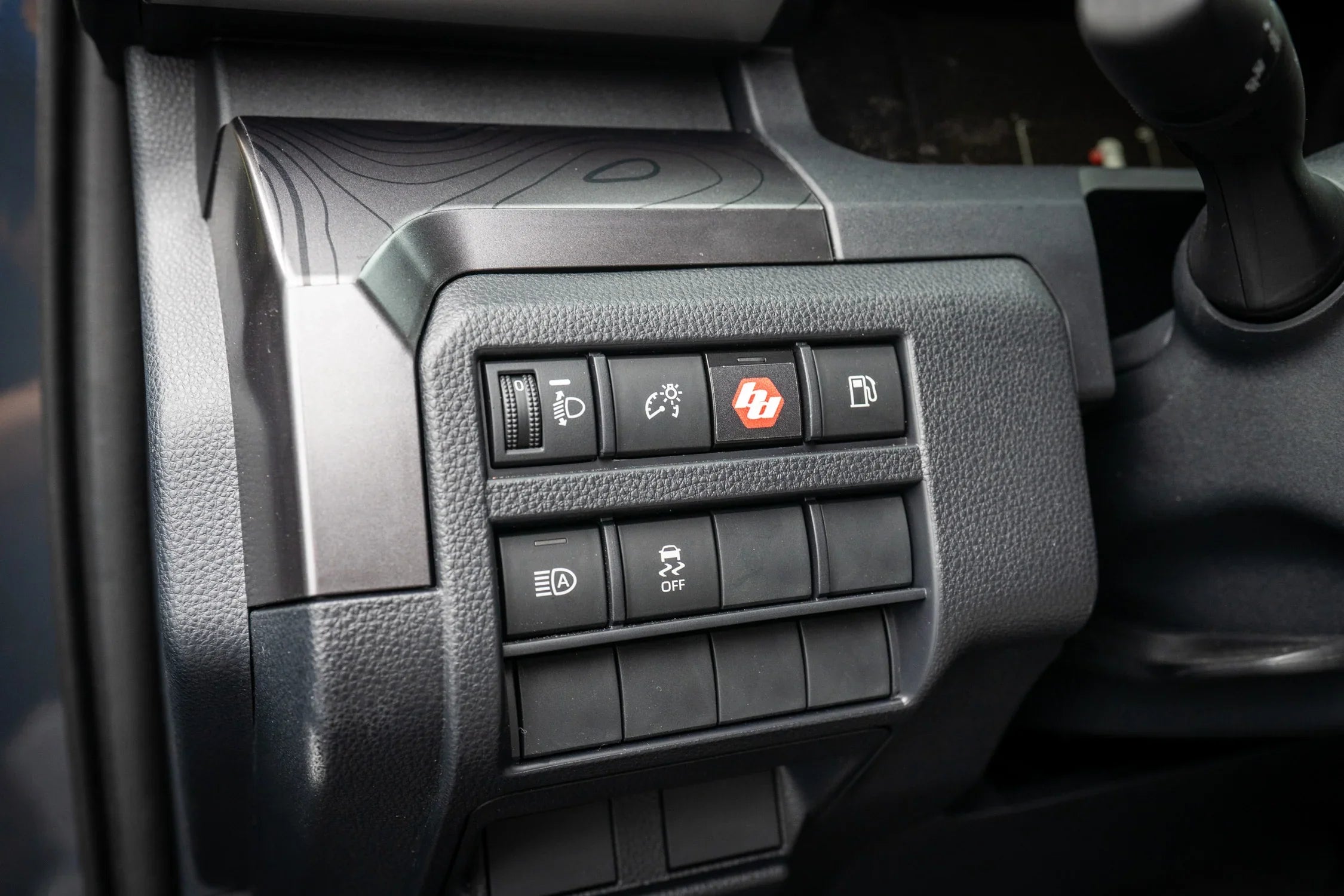 Car control panel with various buttons on a dark background
