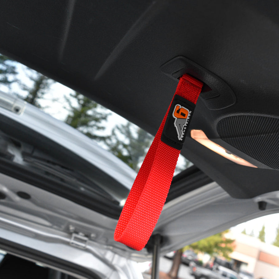 Red strap with a logo attached to a car's sun visor.