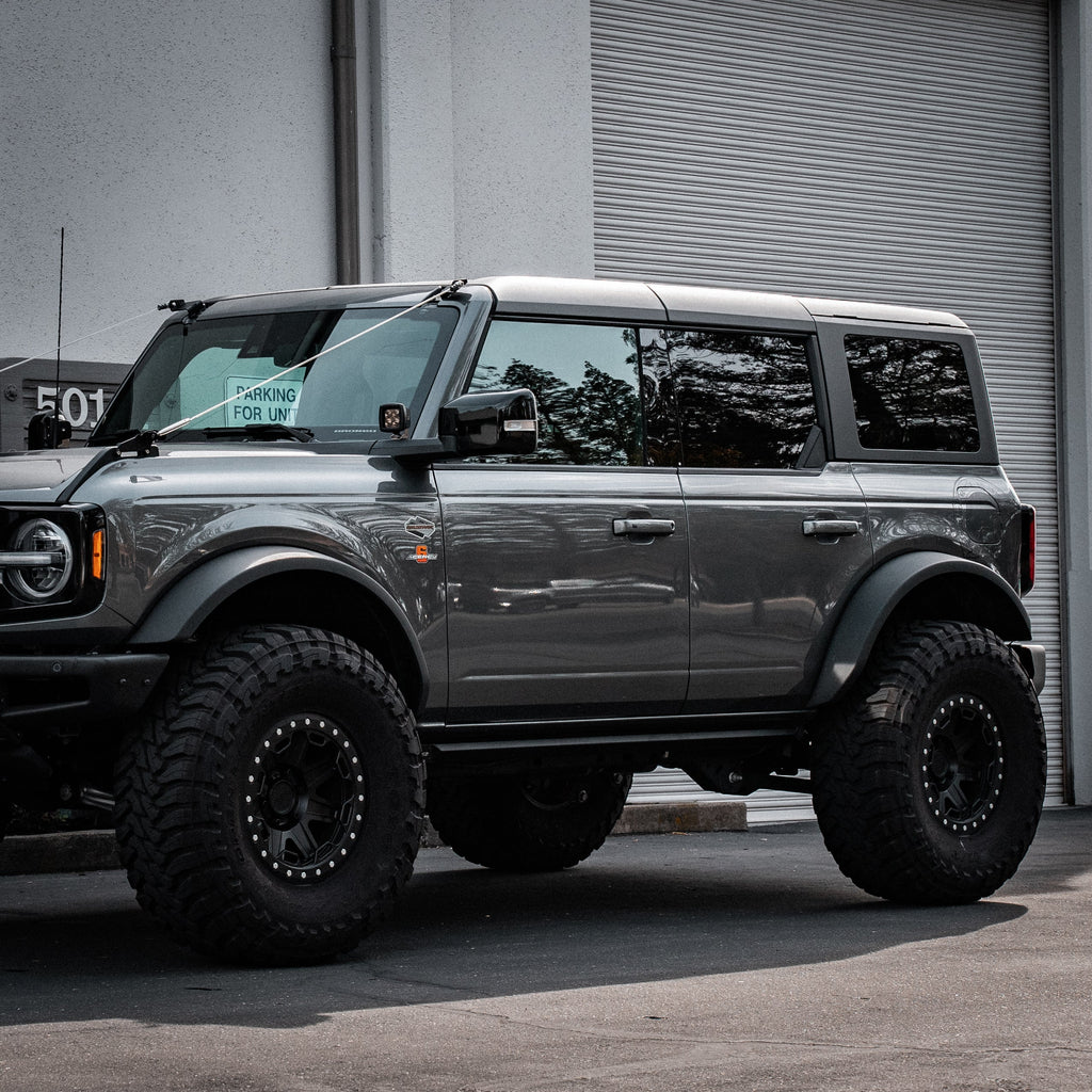 Gray SUV with large tires parked in front of a building