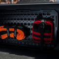Orange and black straps on a black cargo organizer with 'Pacifica' branding.